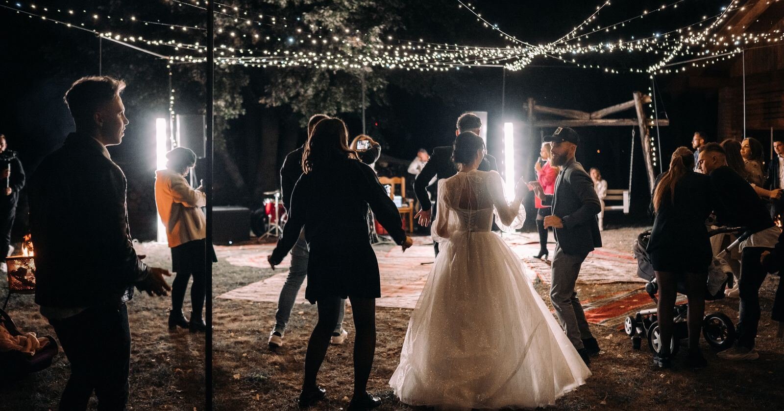 Invités et mariés dansant pendant une soirée de mariage en plein air