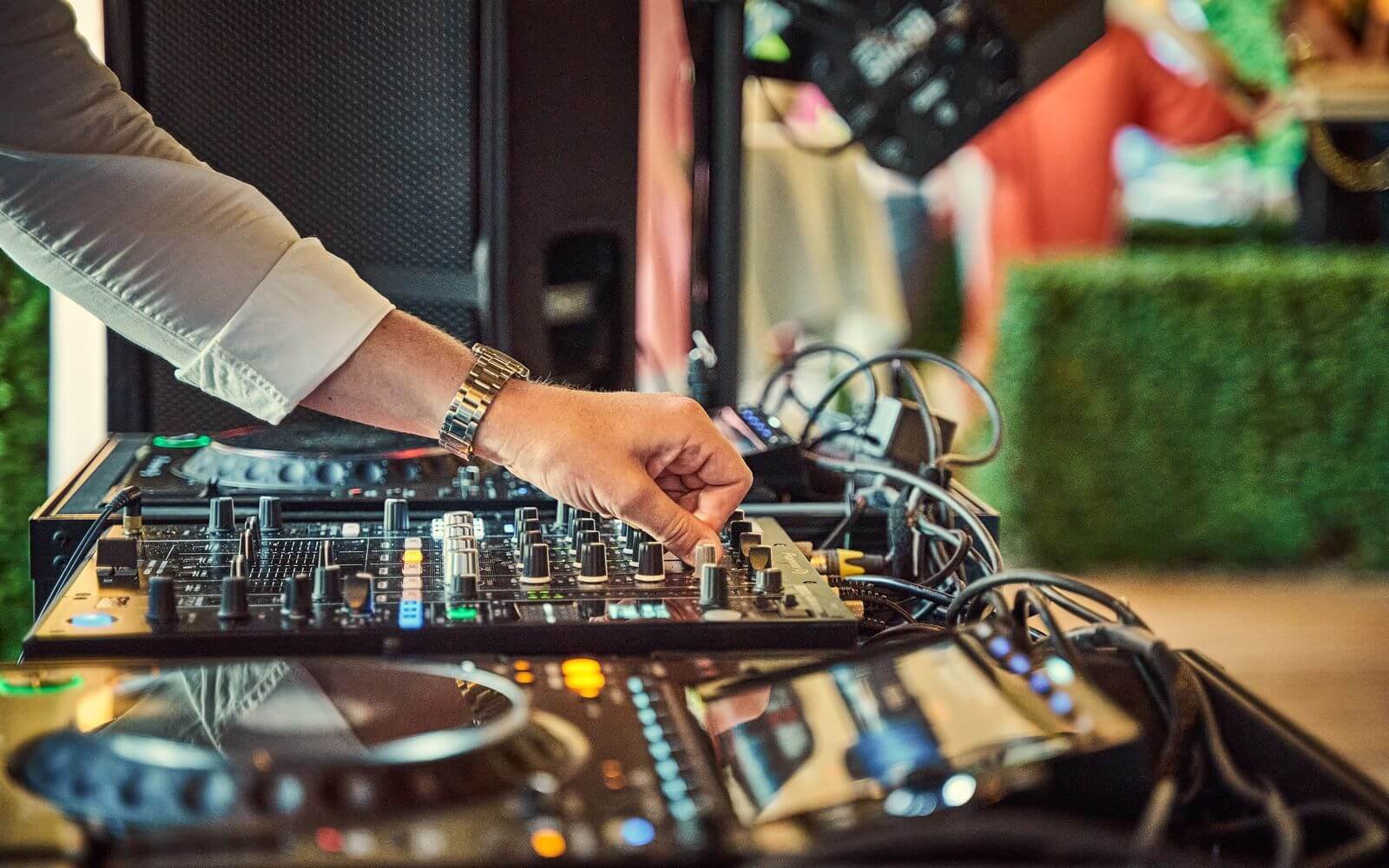 DJ qui règle sa table de mixage pendant un mariage en extérieur