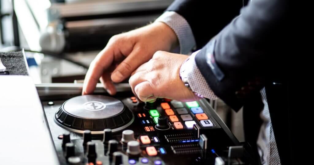 DJ de mariage en costume mixant sur un contrôleur DJ professionnel