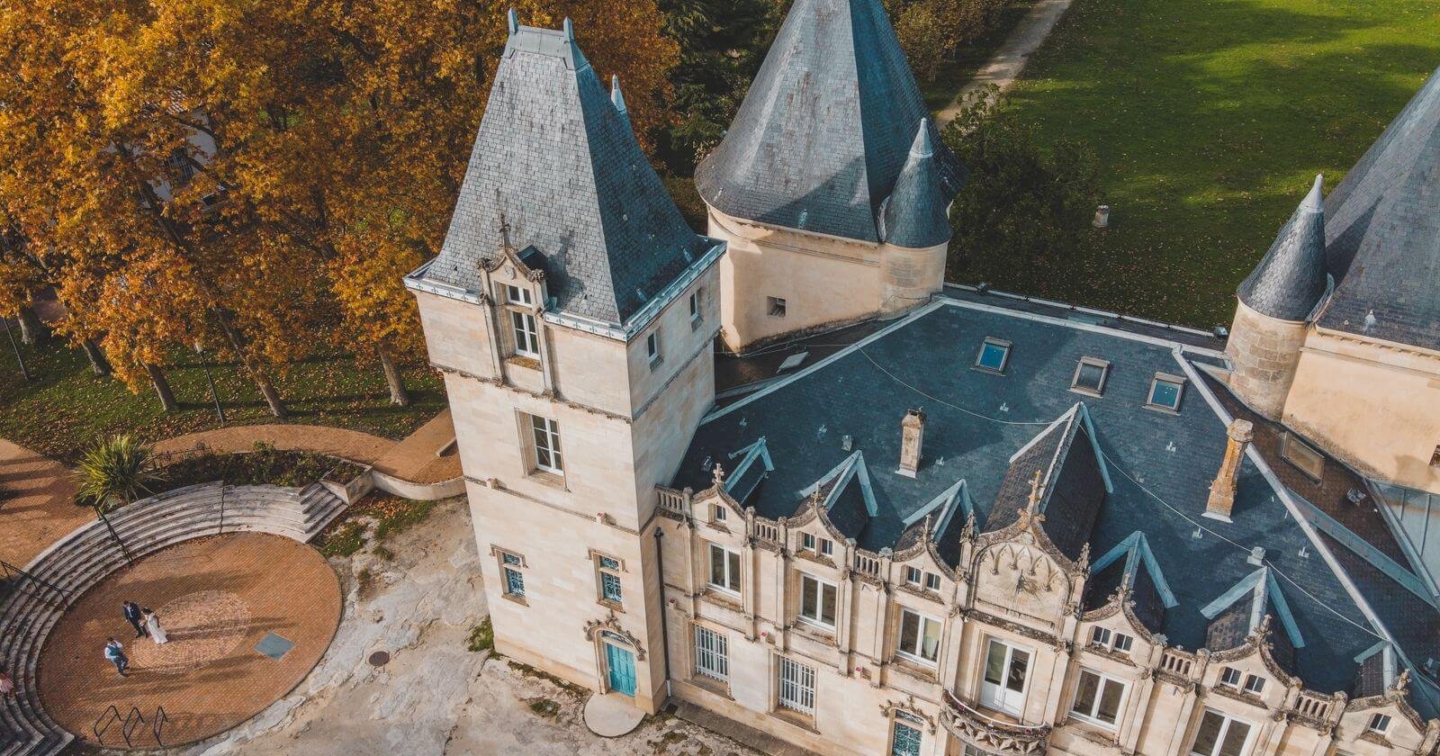Vue aérienne d'un château entouré d'arbres en automne