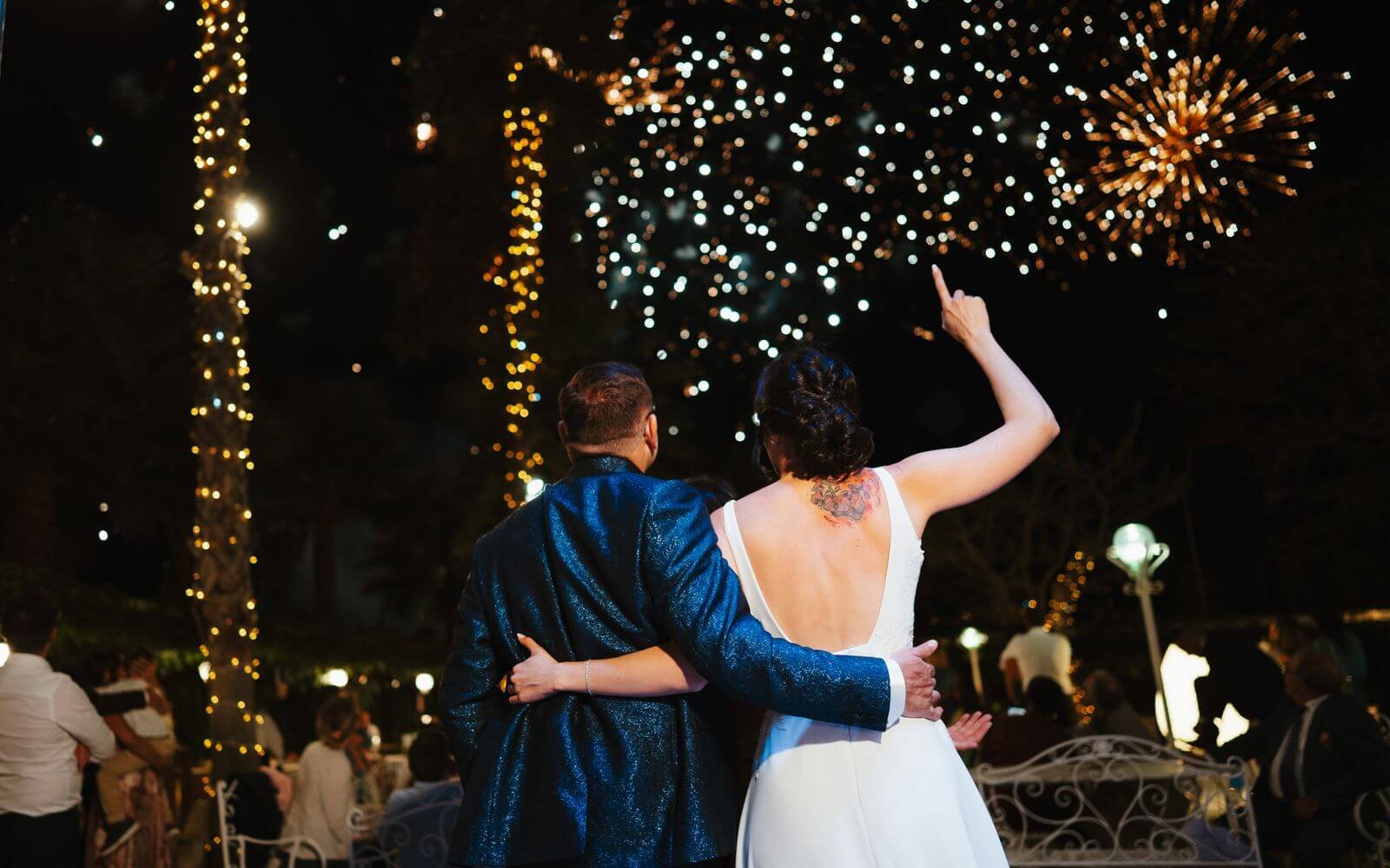 Mariés regardant un feu d'artifice de mariage la nuit
