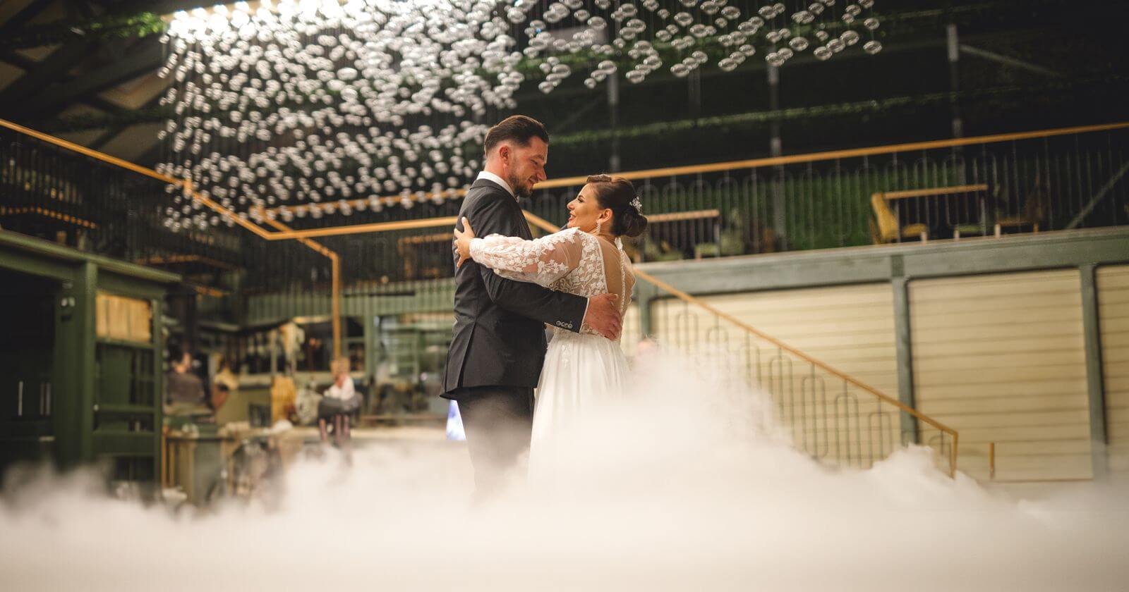 Couple de mariés dansant sur un nuage de fumée blanche