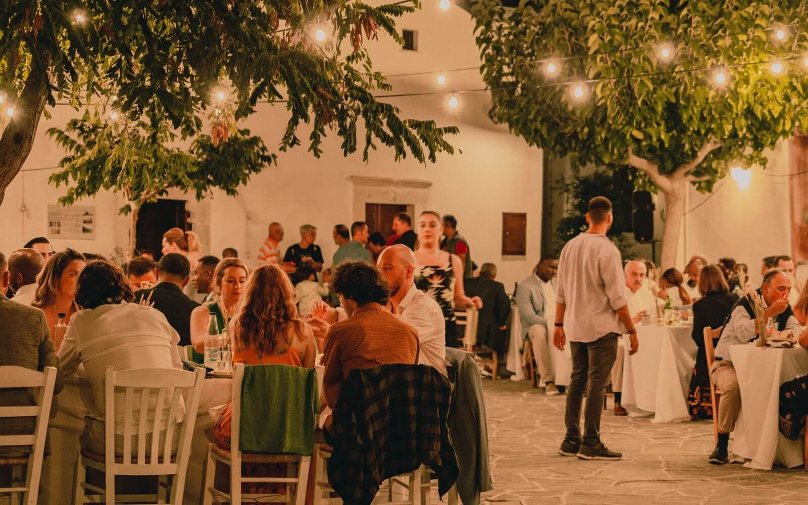 Invités réunis pour un dîner de mariage en extérieur