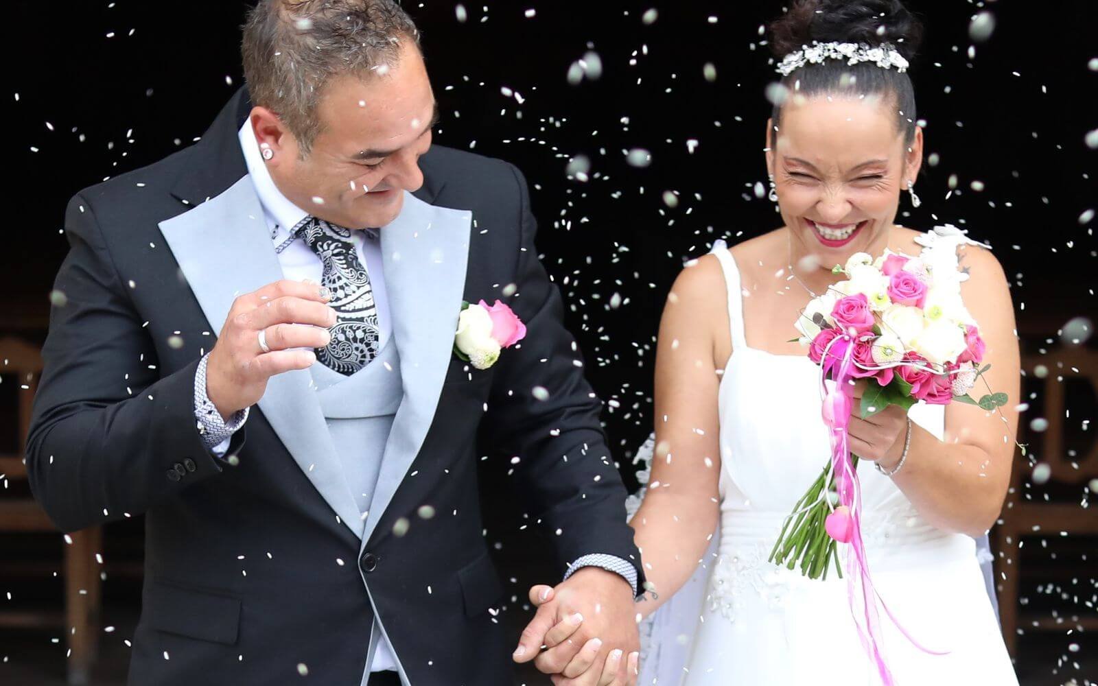 Couple de mariés heureux sous une pluie de confettis