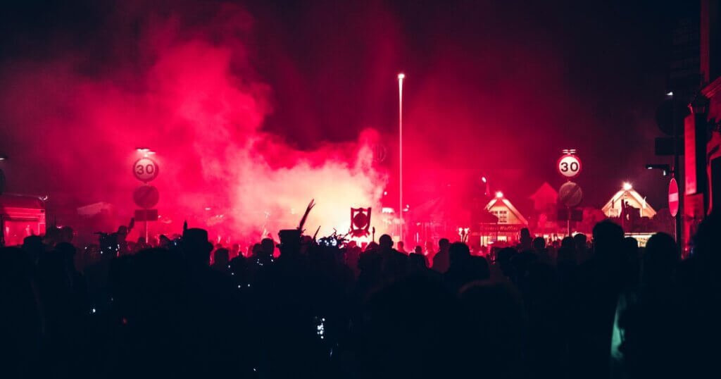 Foule en train de danser sous des lumières rouges pendant une soirée