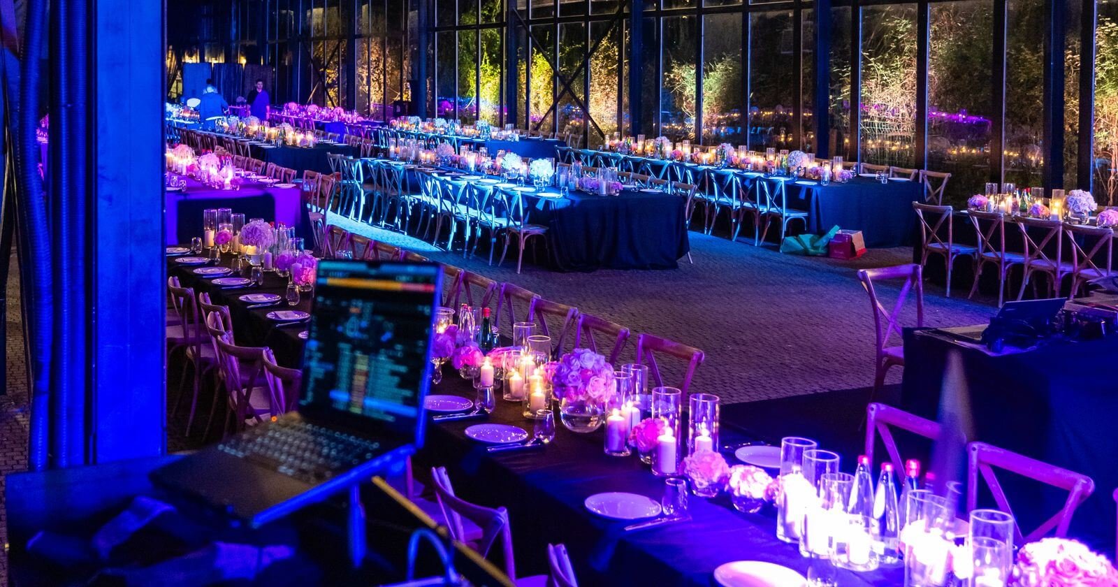 Salle de réception de mariage avec installation DJ et tables éclairées