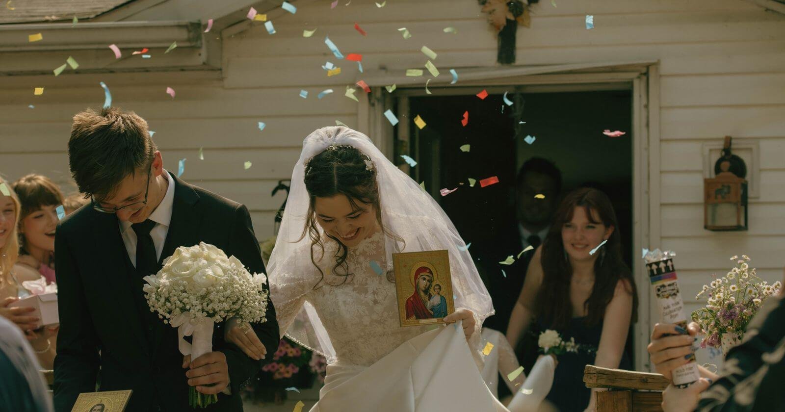 Mariée et marié accueillis par les invités et les confettis